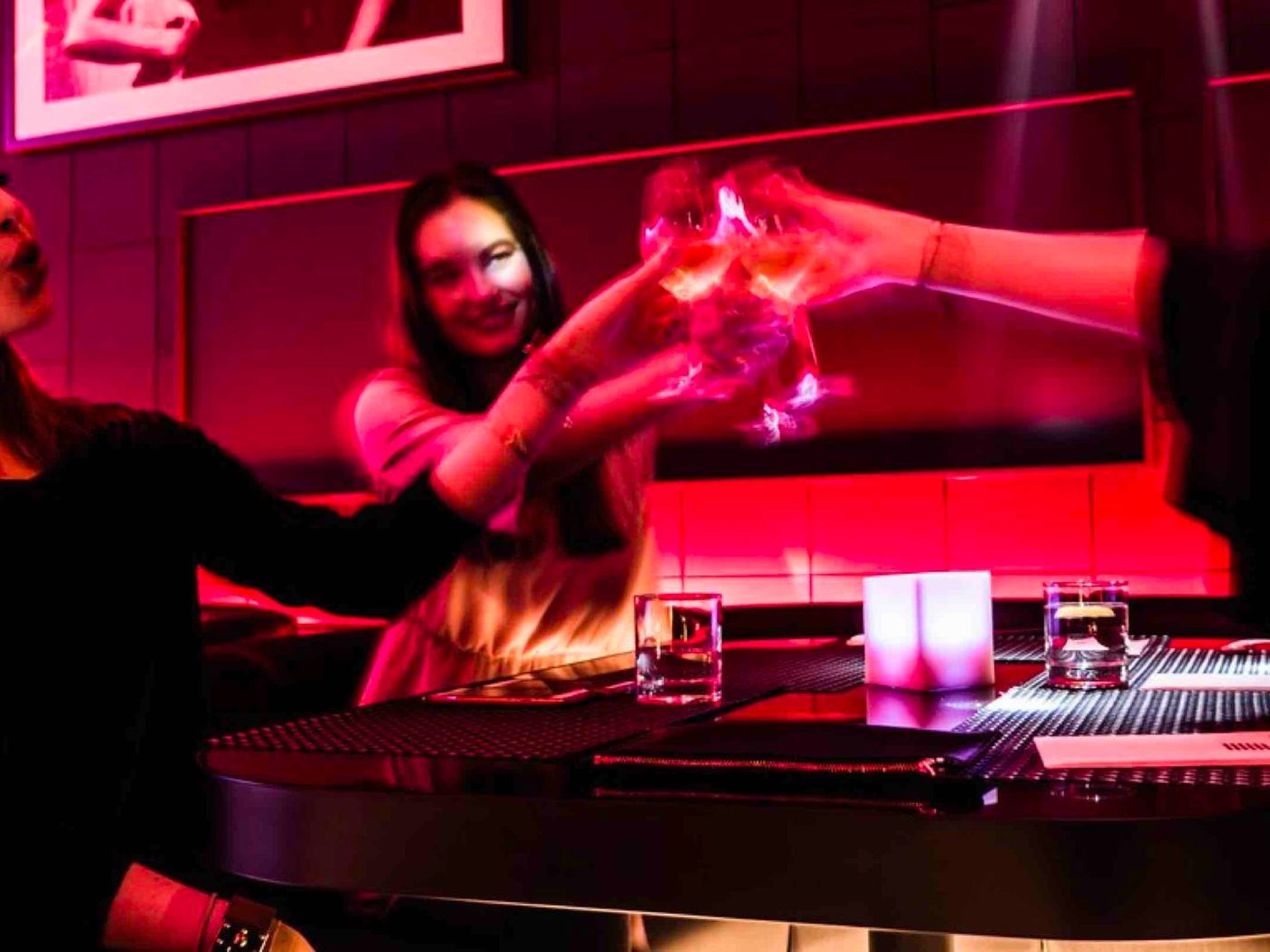 Guests toasting in the pink-lit VIP lounge